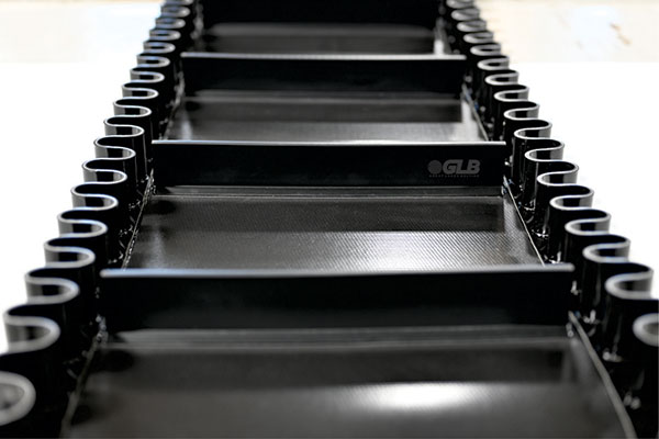 A front facing angle of a conveyor belt with cleats and sidewalls.