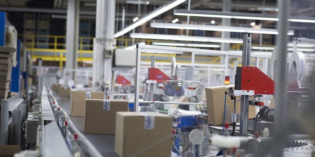 Boxes move on a production conveyor belt at a paper packaging factory.