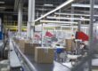 Boxes move on a production conveyor belt at a paper packaging factory.