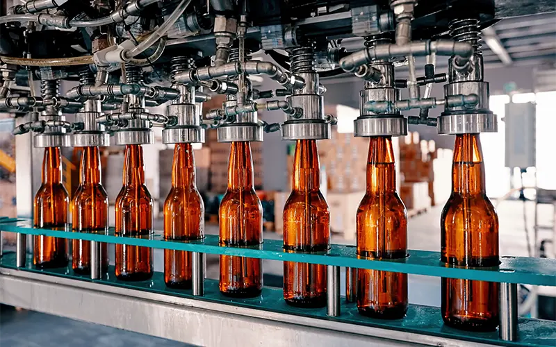 Beer bottles filling on the conveyor belt in the brewery factory