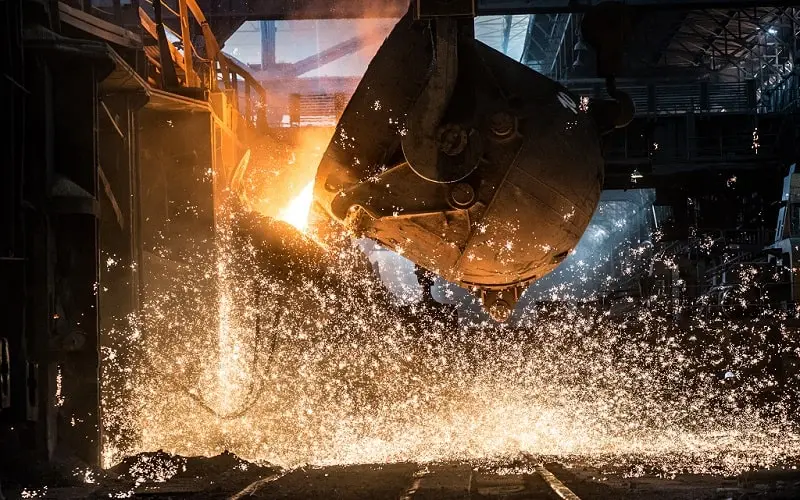 Pouring of liquid metal in open hearth furnace in a factory manufacturing line.