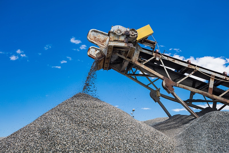Conveyor belt and pile of gravel in open-pit mining